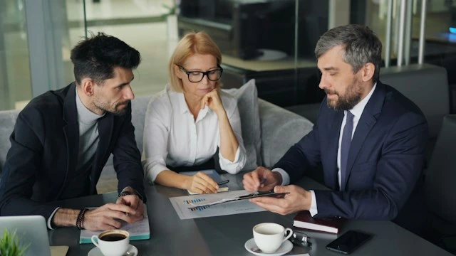 Dos profesionales analizando información de una operación frente a una laptop